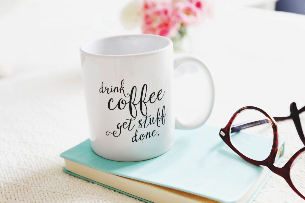 drink-coffee-from-white-mug-with-glasses-and-book-on-wooden-table
